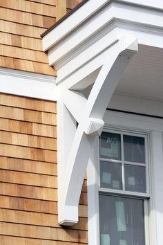 a close up of a window on the side of a house with wood shingles