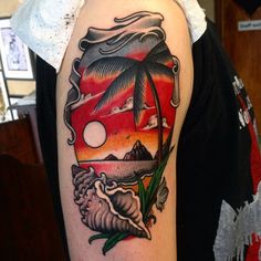 a person with a tattoo on their arm that has an image of a palm tree