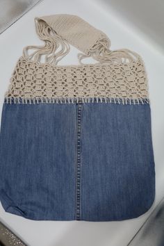 a purse made out of jeans and crochet on top of a white table