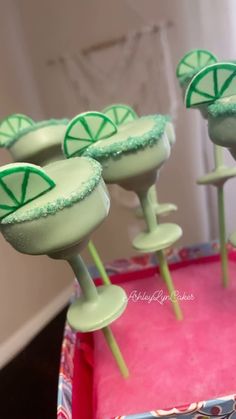 green cake pops sitting on top of a pink box