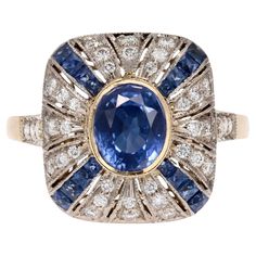 Ring in 18 karat yellow and white gold, eagle head hallmark. An elegant Art Deco-style ring with a cushion-shaped setting featuring a sapphire in the center. The entire cushion is adorned with alternating lines of falling calibrated sapphires and falling modern brilliant-cut diamonds, all openwork. On either side of the head, at the start of the ring, 2x3 modern brilliant-cut diamonds are set. The basket is carefully openworked with arabesque decorations. Weight of the sapphire : 1.50 carat appr Gold Eagle, Vintage Sapphire, Eagle Head, Estilo Art Deco, Sapphire Diamond Ring, Elegant Art, French Art Deco, Three Stone Rings, Cartier Ring