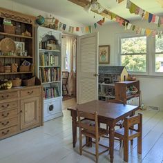 a dining room table and chairs in front of a bookshelf filled with books