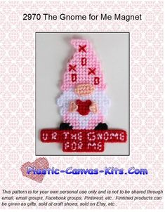 a cross stitch christmas ornament with a santa clause holding a red heart on it