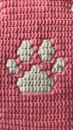 a crocheted pink and white blanket with clouds on it