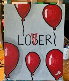 a painting with red balloons and the words lover written in black ink on it, sitting on a easel