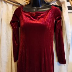 a mannequin wearing a red dress with long sleeves