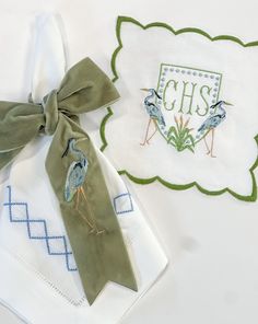 two napkins with embroidered designs on them, one is green and the other is white