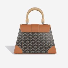 Crafted from tan taurillon leather, the Goyard Saïgon PM is one of the brands iconic pieces. It embodies their trunk features such as the use of the wood handle and leather corners. It's the perfect structured bag for day to day use, and can be carried by the top handle or crossbody strap. SPL Exterior Black goyardine base Tan taurillon leather Silver hardware Wooden top handle and panels Leather enhanced corners Detachable crossbody strap Immaculate condition with the exception of one small scratch the back corner Interior Yellow cotton interior One compartment Slip pocket Immaculate condition Sold with box, dustbag and shoulder strap SPL Height 20cm Width 28cm Depth 12cm Structured Bag, Day To Day, Wooden Tops, To Day, Leather Silver, Bags Designer Fashion, Exclusive Bag, Wood Handle, Handbag Backpack