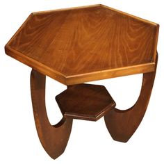 an octagonal wooden table with curved legs and a hexagonal top on one end