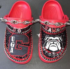 a pair of red slippers with bulldog logo on the bottom and chain around them