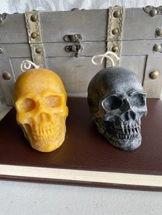 two skulls sitting on top of a table next to an old trunk with metal handles