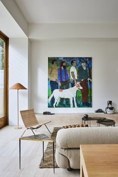 a living room filled with furniture and a painting on the wall