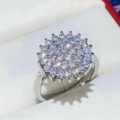 a diamond ring sits in a box on top of a table with an american flag behind it