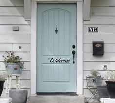 a blue front door with welcome written on it