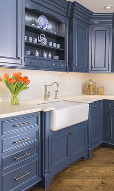 a kitchen with blue cabinets and white counter tops