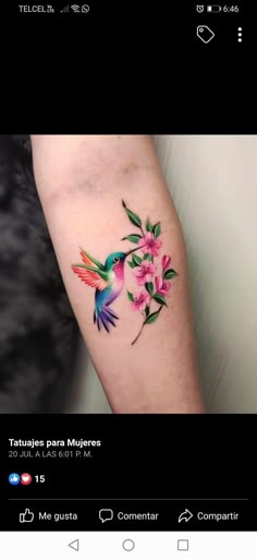 a humming bird with pink flowers on its arm