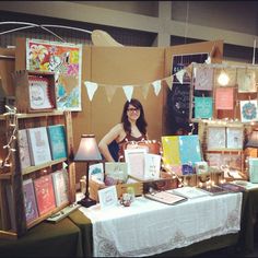 a woman standing in front of a table with pictures on it