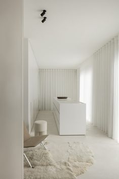 an empty room with white walls and carpeted flooring on the floor, along with a chair