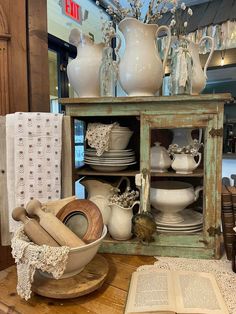 an old cabinet is filled with dishes and vases