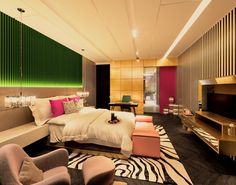 a modern bedroom with zebra rugs and green vertical blinds