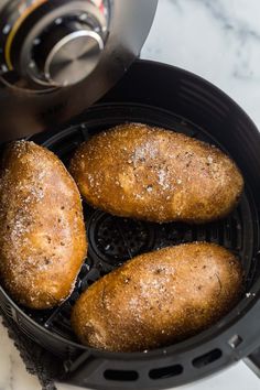 three breads in a deep fryer on a marble counter top next to an air fryer