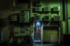 an open door to a building with air conditioners on the wall and bikes parked outside