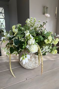 a vase filled with white flowers on top of a wooden table