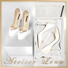 a pair of white high heels in a box with the words atelier leona on it