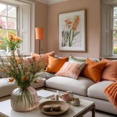 a living room filled with white couches and orange pillows