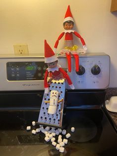 an elf is sitting on top of the stove with marshmallows