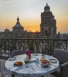 a table with food on top of it in front of a balcony overlooking the city