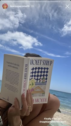 a woman reading a book on the beach