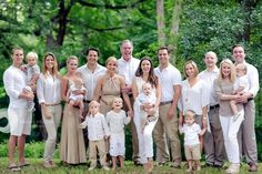 a large group of people posing for a photo in front of some trees and grass