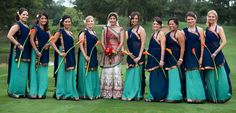 a group of women standing next to each other on top of a lush green field