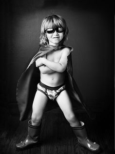 a small child in a costume and boots is posing for a black and white photo