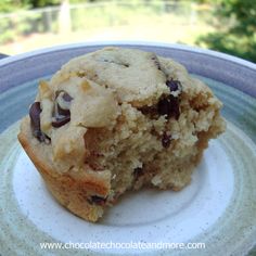 a muffin sitting on top of a white and blue plate next to a tree