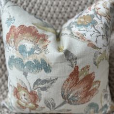 a close up of a flowered pillow on a chair with the back cushion down