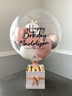 a birthday cake and balloons in a box