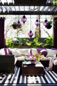 an outdoor living room with purple and white decor