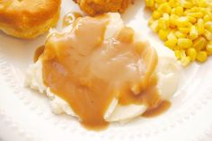 a white plate topped with mashed potatoes, corn and gravy