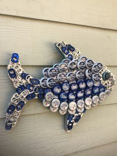 a fish made out of beer caps on the side of a building