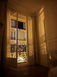 an open balcony door with the light shining in from it's windows and shutters