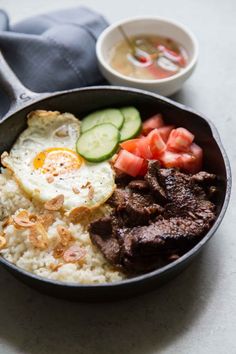 a bowl filled with rice, meat and vegetables