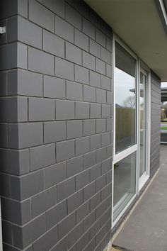 the side of a building with a parking meter in front of it and an open window