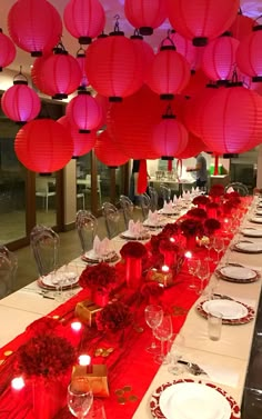 a long table is set with red lanterns and plates