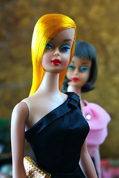 two dolls are standing next to each other