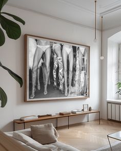 a living room filled with furniture and a painting hanging on the wall over a coffee table