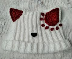 a white knitted bear hat with red pom poms