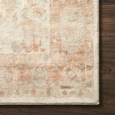 an orange and white rug on top of a wooden floor next to a lamp shade