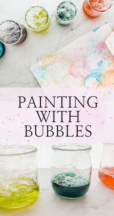 the words painting with bubbles are in front of some glass jars filled with colored liquid